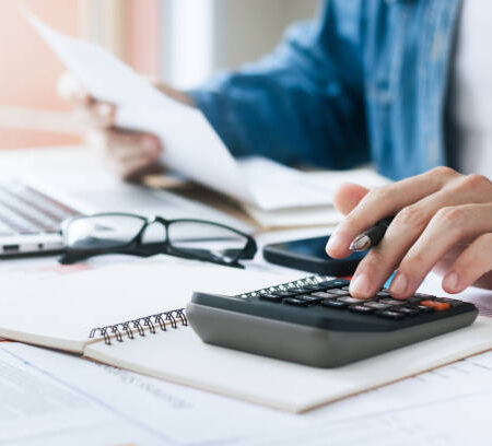 Investors are calculating profits and costs with calculators, growth and investment chart analysis, business planning and strategies to maximize sales profits. Long term business plan.