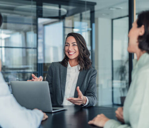Shot of group of business persons in business meeting. Three entrepreneurs on meeting in board room. Corporate business team on meeting in modern office. Female manager discussing new project with her colleagues. Company owner on a meeting with two of her employees in her office.